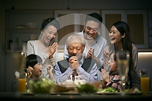 Three generation asian family celebrating grandpa`s birthday at home