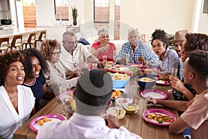 Three generation African American  family sitting at dinner table celebrating together,close up