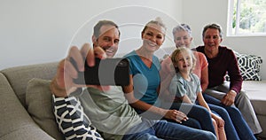 Three generation caucasian family taking a selfie together with smartphone at home