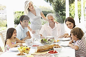 Three Generation Family Enjoying Meal Outdoors