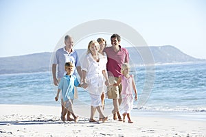 Three Generation Family On Holiday Walking On Beach