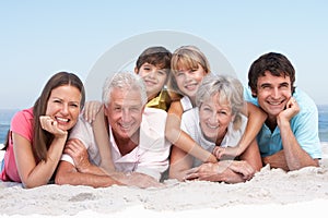 Three Generation Family Relaxing On Beach