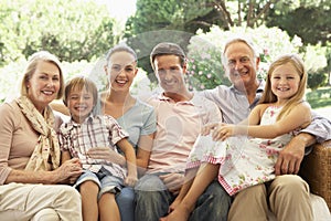 Three Generation Family Sitting On Sofa Together