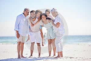 Three generation family on vacation standing together at the beach. Mixed race family with two children, two parents and