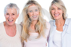 Three generations of cheerful women smiling at camera