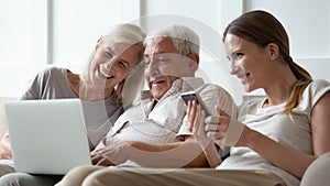 Three generations family with modern gadgets at home