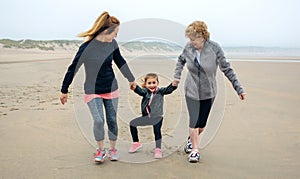 Three generations female running on the beach