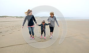 Three generations female running on the beach