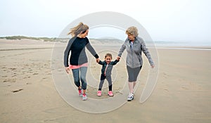 Three generations female running on the beach