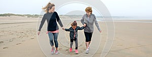 Three generations female running on the beach