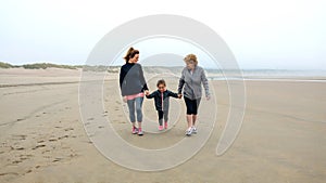 Three generations female walking on the beach