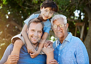 Three generations of handsome. Portrait of a cute boy posing outside with his father and grandfather.