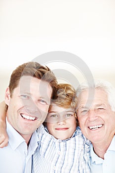 Three generations of handsomeness. Cropped portrait of a young boy standing with his father and grandfather.