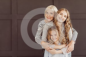 Three generations of happy women looking at camera