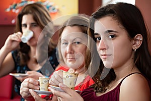 Three generations of hispanic women drinking coffee photo