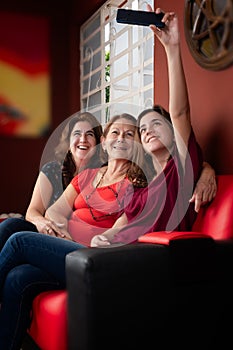 Three generations of hispanic women taking a selfie