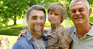 Three generations of men smiling at camera