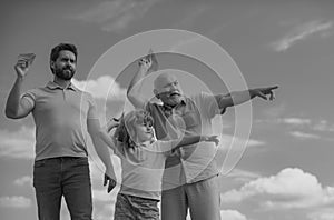 Three generations of men together, portrait of smiling son, father and grandfather with a toy airplane. Child boy