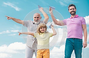 Three generations of men together, portrait of smiling son, father and grandfather with a toy airplane. Child boy