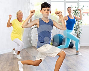 Three generations of mother, grandmother and teen son learn sports Latin American dances