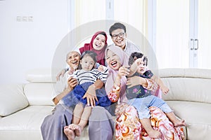 Three generations of muslim family smiling at camera