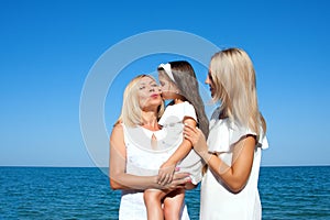 Three generations of women on the beach