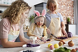 Three generations of women cooking together in the kitchen