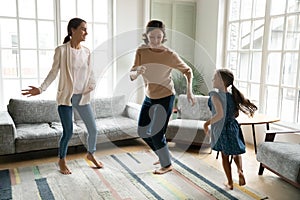 Three generations of women dance together at home photo