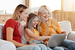 Three generations women family using laptop at home