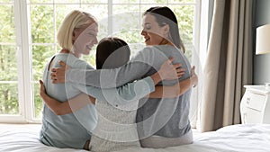 Three generations of women hug showing family unity