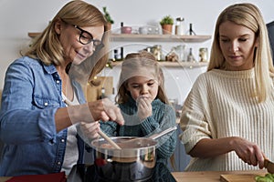 Three generations of women preparing food in the kitchen