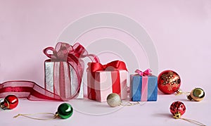 Three gift boxes on light pink background.