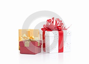 Three gift boxes tied with colored satin ribbons bow on white