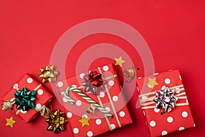 Three gift boxes wrapped with ribbons and bow on red background Christmas Festive Holiday Background Copy Space