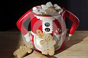 Three gingerbread cookies in a hot chocolate cute Mrs. Clause mug with marshmallows