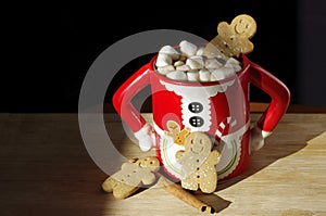 Three gingerbread cookies in a hot chocolate cute Mrs. Clause mug with marshmallows