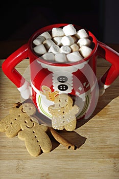 Three gingerbread cookies in a hot chocolate Mrs. Clause cute mug with marshmallows