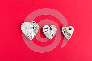 Three gingersnap cookies in form of heart on red background