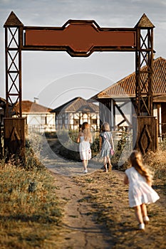 Three girl coming out of the gate of the village