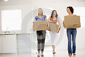 Three girl friends moving into new home smiling