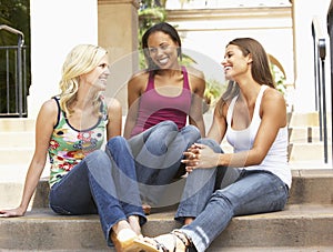 Three Girlfriends Sitting On Steps Of Building