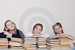 Three girls in the classroom studying many books