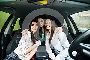Three girls driving in a car and having fun