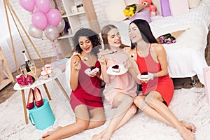 Three girls eating cake. They are celebrating women`s day March 8.