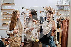 Three girls in an eco-friendly store, each holding a bag