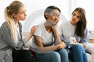 Three Girls Engaged in Serious Conversation in Bright Living Room