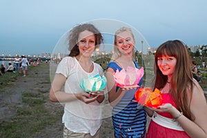 Three girls are getting ready to launch water lanterns