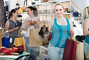 Three girls holding a paper shopping bags in the boutique