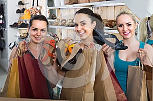 three girls holding a paper shopping bags in the boutique