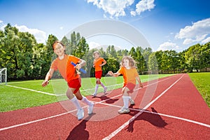 Three girls with one relay baton running photo